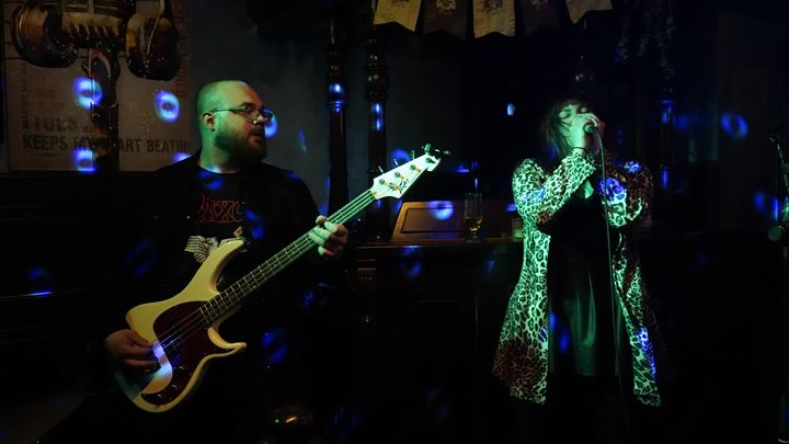 Diamond performing in blue and green club lighting